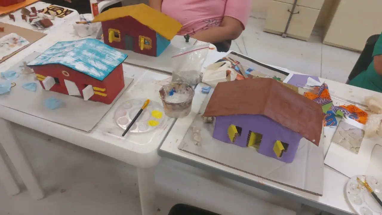 Painted wooden house model on the MiSO workshop table