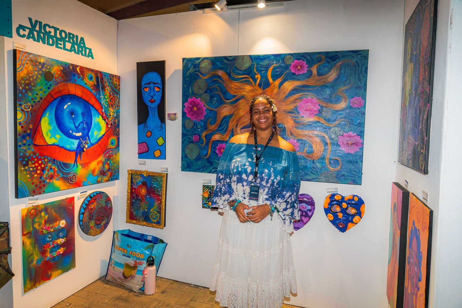 An artist at her stand, Aruba Art Fair 2026