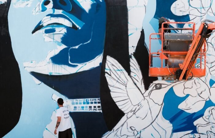 A mural being painted from a lift in San Nicolas